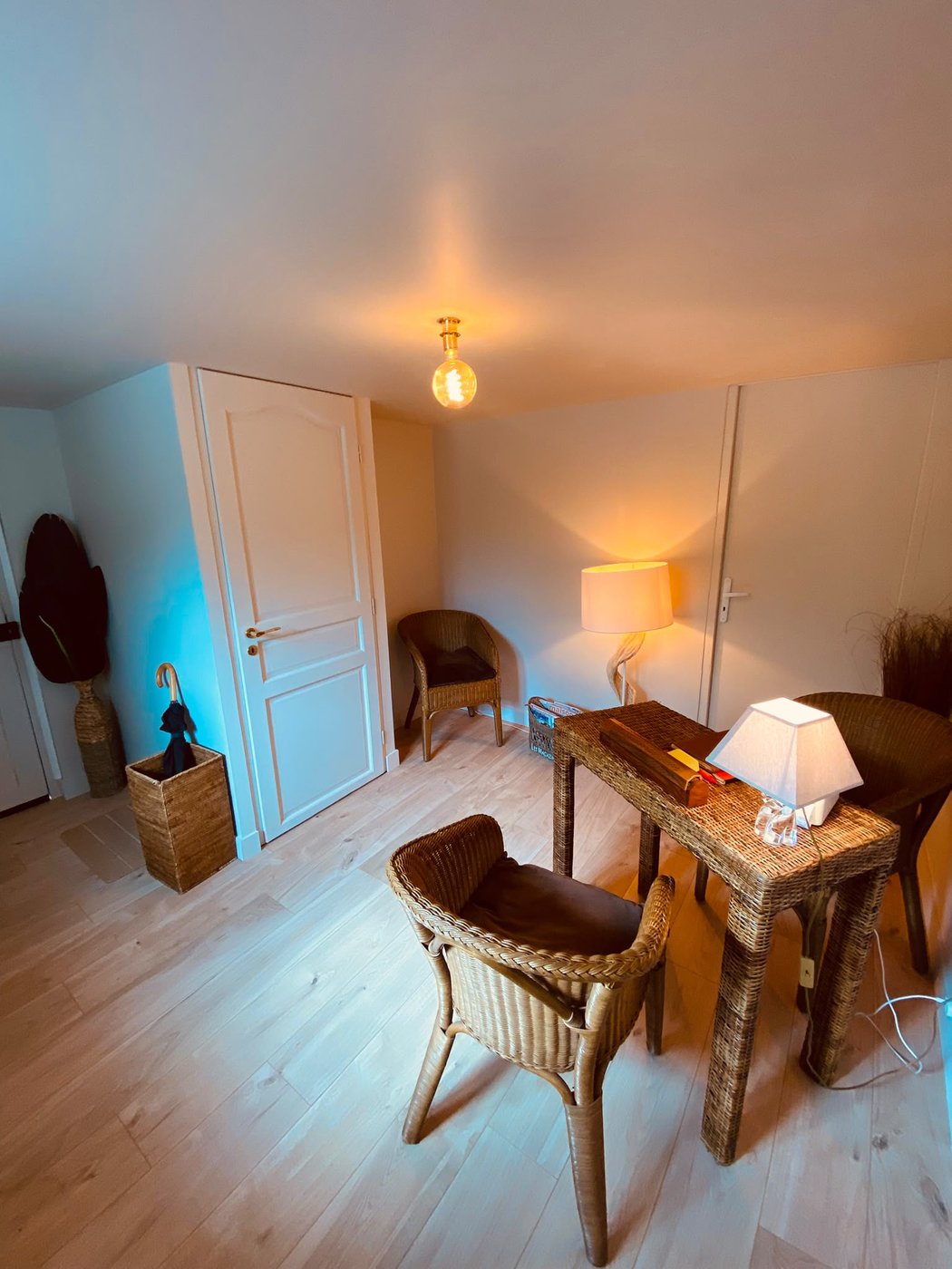 Salon d'accueil avec mobilier en rotin et ambiance chaleureuse